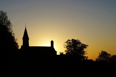 Silhouette of building against clear sky at sunset