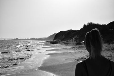 Rear view of woman looking at sea against clear sky
