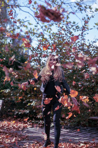 Full length of woman standing by tree