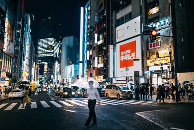 People walking on city street at night