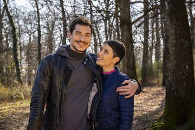 Young smiling couple is walking in the woods. 