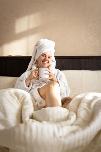 Portrait of woman lying on bed at home