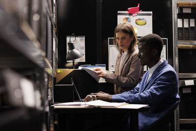 Young woman using laptop while sitting in office