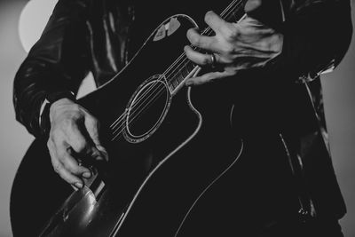 Midsection of man playing guitar