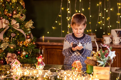 Full length of boy holding christmas tree