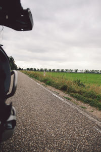 Country road on field against sky