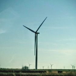 Low angle view of windmill on field against sky