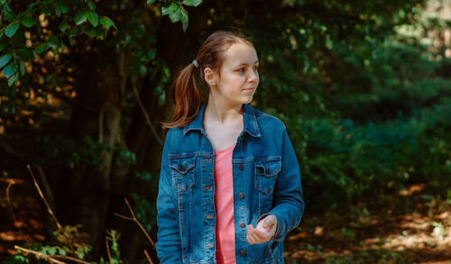 Young woman standing against plants