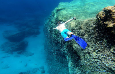 Shirtless man swimming undersea