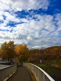 Road amidst trees against sky during autumn