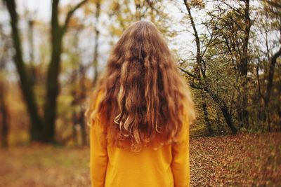 Rear view of woman standing in forest