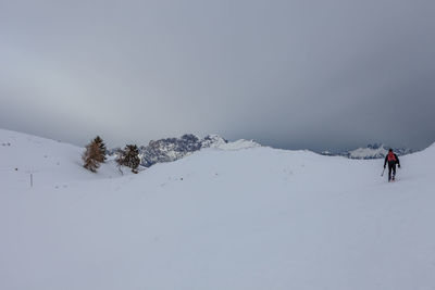 People skiing on snowcapped mountain against sky