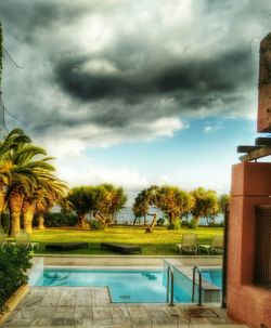 Palm trees against cloudy sky