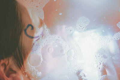 Close-up of young woman in bathtub