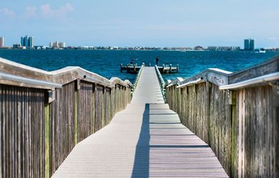 Wooden pier on sea against sky