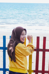 Young woman smiling while standing on beach