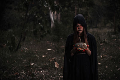 Woman standing on land in forest