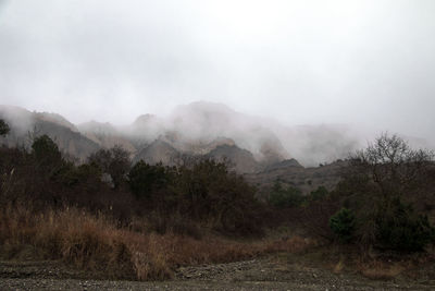 Scenic view of landscape against sky during foggy weather