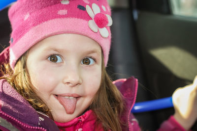 Close-up portrait of happy child.  little cute girl sticking her tongue out.  showing the tongue
