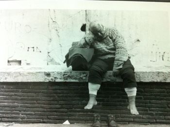 Full length of man sitting on wall