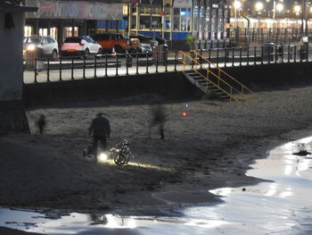 High angle view of people on snow in city at night