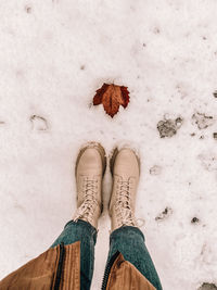 Low section of person standing on snow covered ground