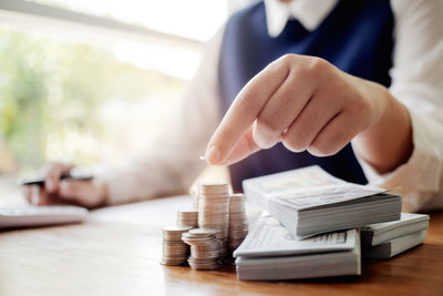 Midsection of man holding stack on table