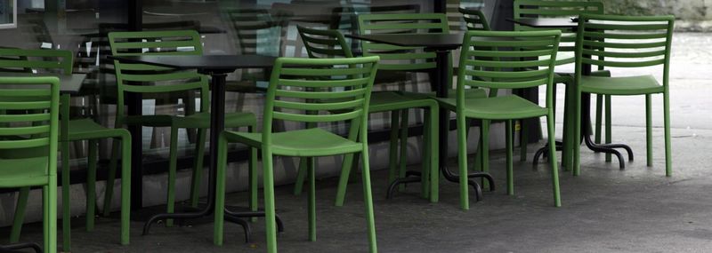 Empty chairs and tables arranged in row