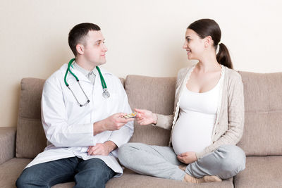 Doctor is giving pills to a pregnant woman and explaining how to use them. treatment 