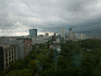 City buildings seen through wet glass window