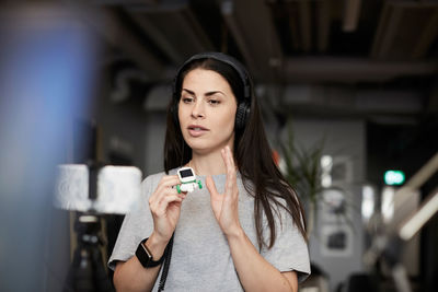 Female entrepreneur giving presentation on solar toy car through conference call in office