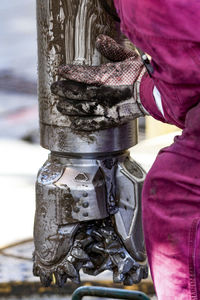 Worker guides drill bit into drill hole on drill floor