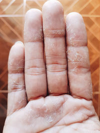 Close-up of hand on wet floor at home