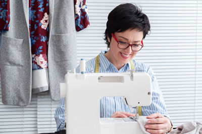 Craftswoman sewing textile on machine at workshop