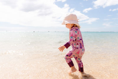 Full length of girl on beach against sky