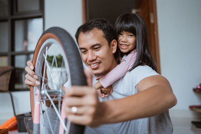 Father repairing bicycle with daughter at home