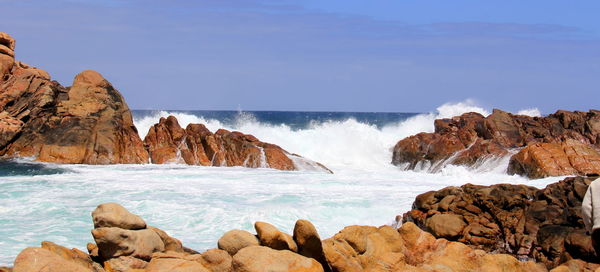 Scenic view of rocks in sea against sky