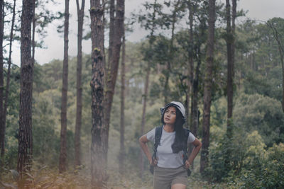 Full length of man standing by trees in forest