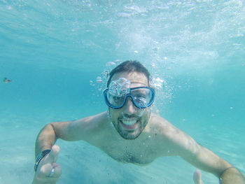 Man swimming underwater in sardinia's sea