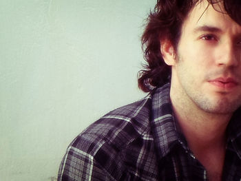 Close-up portrait of young man against gray background