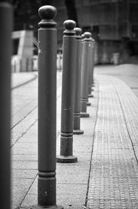 Close-up of metallic structure on sidewalk by building