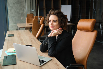 Portrait of young woman using laptop at home