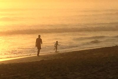 Silhouette of woman against sky at sunset