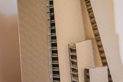 Corrugated board of different sizes stands against the wall