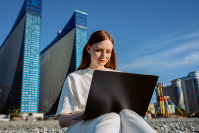 A girl with a laptop works on the beach. freelance programmer. realtor. high quality photo