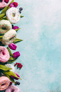 High angle view of donuts with tulips and berry fruits on table