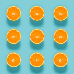 Close-up of sliced orange fruits on blue background