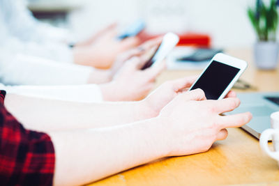 Midsection of man using mobile phone on table