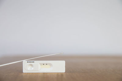 Close-up of mobile phone on table against wall