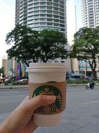 Woman hand holding glass of building